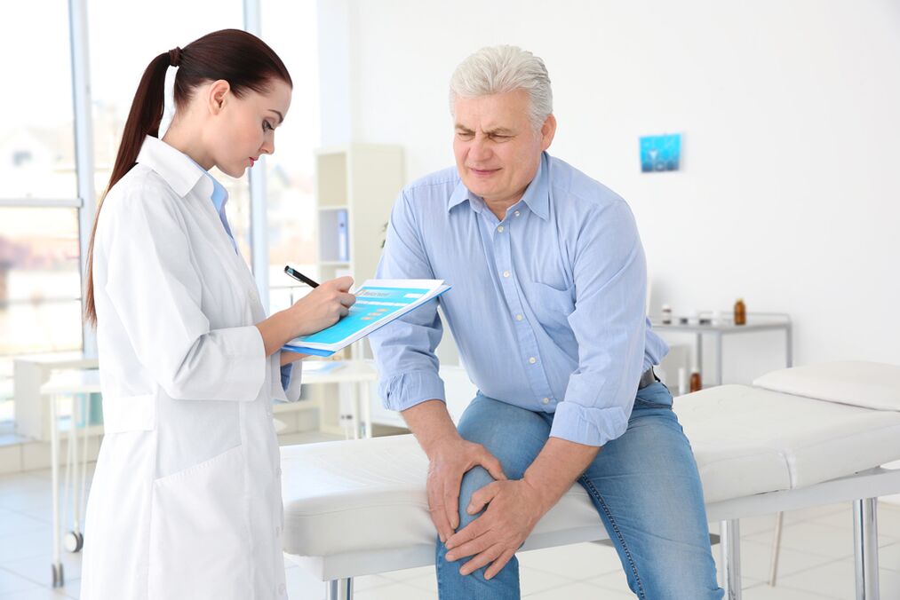 Doktor, diz ekleminin artrozu olan bir hastaya tedavi yöntemini belirler.